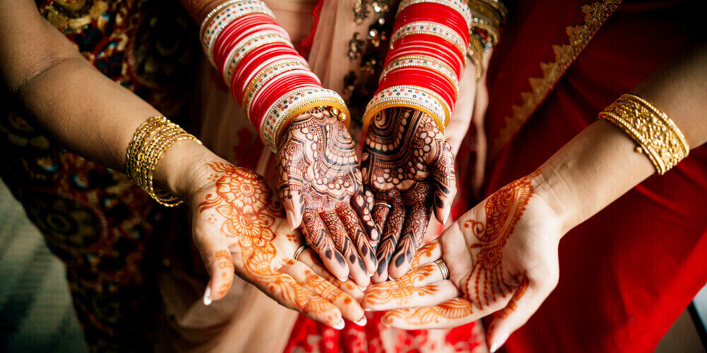 Indian bride and bridesmaids with mehndi/henna design on their hands